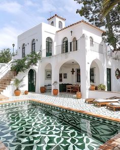 a large white house with a pool in front of it