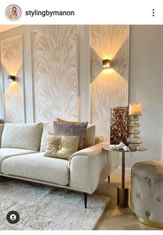 a living room filled with furniture and wall sconces on either side of the couch