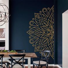 a dining room with a table and chairs next to a wall painted in dark blue