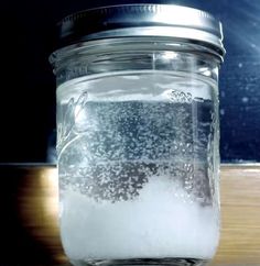 a glass jar filled with liquid sitting on top of a wooden table