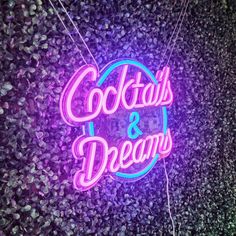 a neon sign that says cocktails and dreams on the side of a purple wall