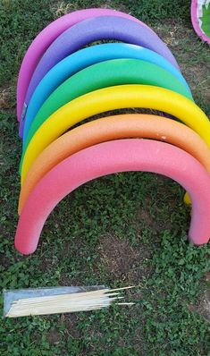 a bunch of different colored surfboards laying on the ground next to each other in some grass