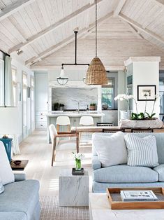 a living room filled with furniture next to a kitchen