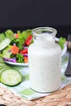 a jar filled with white liquid sitting on top of a green and white checkered table cloth