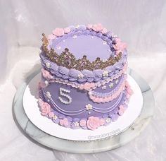 there is a purple cake with pink flowers on the top and number 5 on the bottom