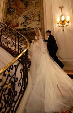 a bride and groom walking down the stairs at their wedding ceremony in an ornate building