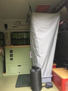 the inside of a camper with an awning and storage bins on the floor