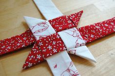 a red and white piece of fabric sitting on top of a wooden table