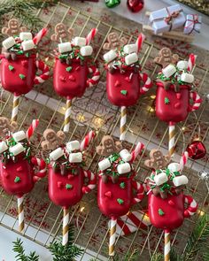 red cups filled with candy and marshmallows on top of a table next to christmas decorations