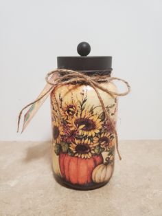 a jar with sunflowers and pumpkins painted on it