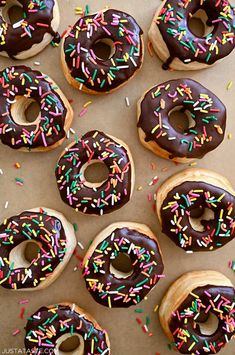 there are many donuts with chocolate frosting and sprinkles on them