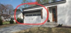 a white house with a red circle in front of it that is circled around the garage