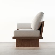 a chair that is sitting on top of a wooden block in front of a white wall