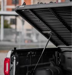 the back end of a pickup truck with its cargo compartment open and it's lights on