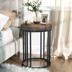 a small table with some pictures on it next to a couch and window sill