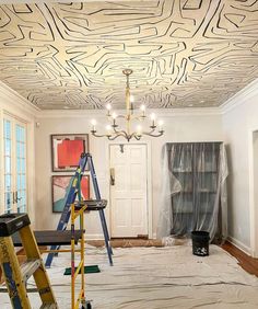 a room that has been painted with white paint and some ladders on the floor