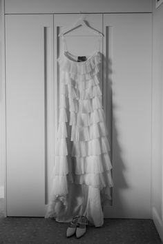 a dress hanging on a hanger next to a pair of shoes in front of a door