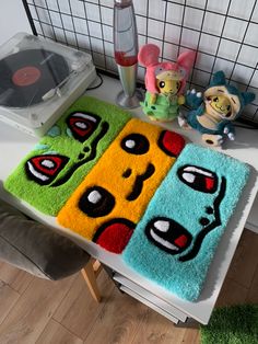 two rugs with cartoon characters on them sitting on a table next to a record player