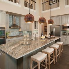 a large kitchen with marble counter tops and stools