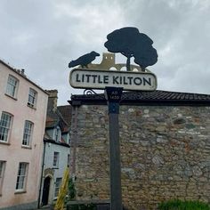 there is a sign that says little killon on the side of the street in front of some buildings