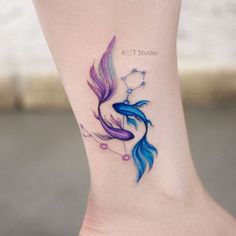 a small tattoo on the ankle of a woman's foot with a blue and purple fish