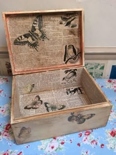 an open box with butterflies on it sitting on a blue table cloth covered tablecloth