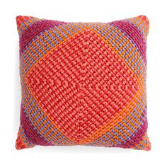 an orange and pink pillow with multicolored squares on it's back side