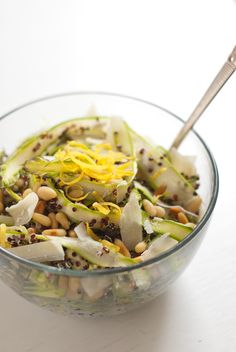 a glass bowl filled with vegetables and nuts