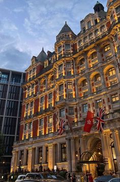 a very tall building with many windows and flags on it's sides at night