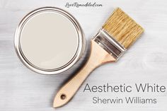 a paint can and brush sitting on top of a white wooden table with the words snowbound sherylin williams