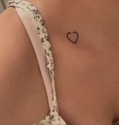 a woman with a small heart tattoo on her back