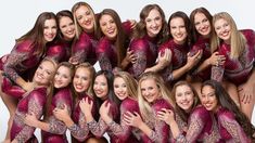 a group of women in red and purple outfits posing for a photo together with their arms around each other