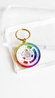 a keychain with a multi - colored wheel on it sitting on a white surface