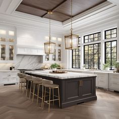 a large kitchen with white cabinets and marble counter tops, along with bar stools