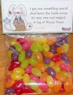 a bag filled with jelly beans sitting on top of a wooden table next to a sign