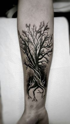 a man's arm with a tree tattoo on it