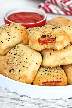 a white bowl filled with pastries covered in cheese and tomato