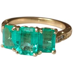 This stunning Colombian emerald 18k gold three stone engagement ring features in center; 1.40ct vs glowing-lustrous Colombian emerald measuring 7.85x6.08mm. On either side of this beautiful vs stone sits emerald cut matching emeralds, totaling approx. .1.70cts. All set in 18K yellow gold setting with a beautiful engraving. ...A wonderful addition to any fine collection! Currently a ring size US 7 Total gemstone weight: 3.10 carats Face of Ring Measurements: 16.50mm x 8.40mm Total ring weight: 5. Emerald Three Stone Ring, Art Deco Emerald, Contemporary Engagement Rings, Handmade Jewelry Ring, Modern Engagement Rings, Three Stone Ring, Colombian Emeralds, Yellow Gold Engagement, Yellow Gold Setting