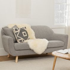 a living room with a gray couch and white rug