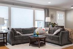 a living room with two couches and a coffee table in front of the window