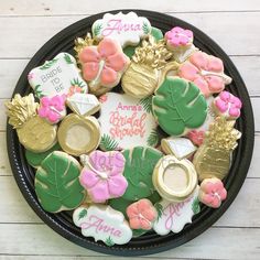 a black plate topped with lots of decorated cookies