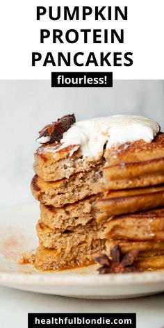 a stack of pancakes with whipped cream on top and the words pumpkin protein pancakes flourless