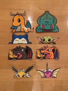 six different pokemon stickers on a wooden floor with one being a pikachu and the other is a dragon