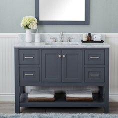 a bathroom vanity with two sinks and a large mirror above it, along with a rug on the floor