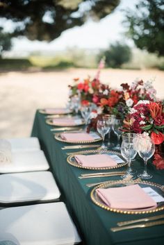 the table is set with wine glasses and place settings for guests to sit down at