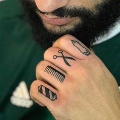 a close up of a person with tattoos on their hands and scissors in the other hand