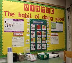 a bulletin board with writing on it in front of a green table and wooden chair