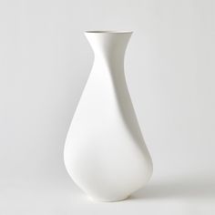 a white vase sitting on top of a table