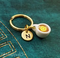 a close up of a keychain with a lemon in the shape of a letter n