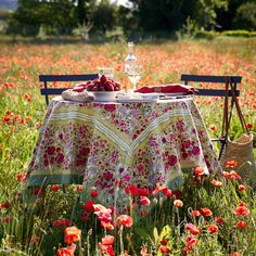 a table in the middle of a field with red flowers